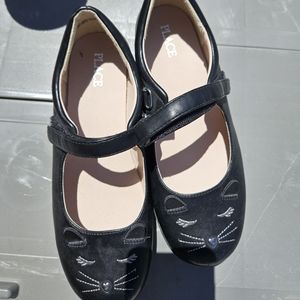 Children place dress shoes they are size 6 and black with a cat face